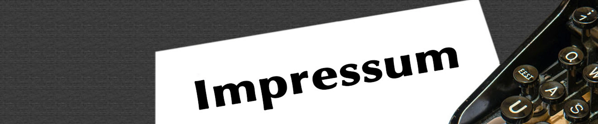 Es ist ein Schreibtisch mit schwarzer Oberfläche in der Draufsicht zu sehen. Rechts im Anschnitt befindet sich eine alte Schreibmaschine. Quer übers Bild befindet sich ein weißes Schild mit der Aufschrift Impressum